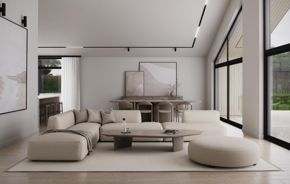 Aurora living room with vaulted ceiling, floor-to-ceiling windows, neutral sectional sofa and ottoman, oval coffee table, and adjacent dining area filled with natural light