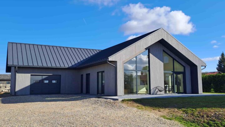 Aurora modern Scandinavian home completed by customer with large gable windows, wood cladding and metal roof