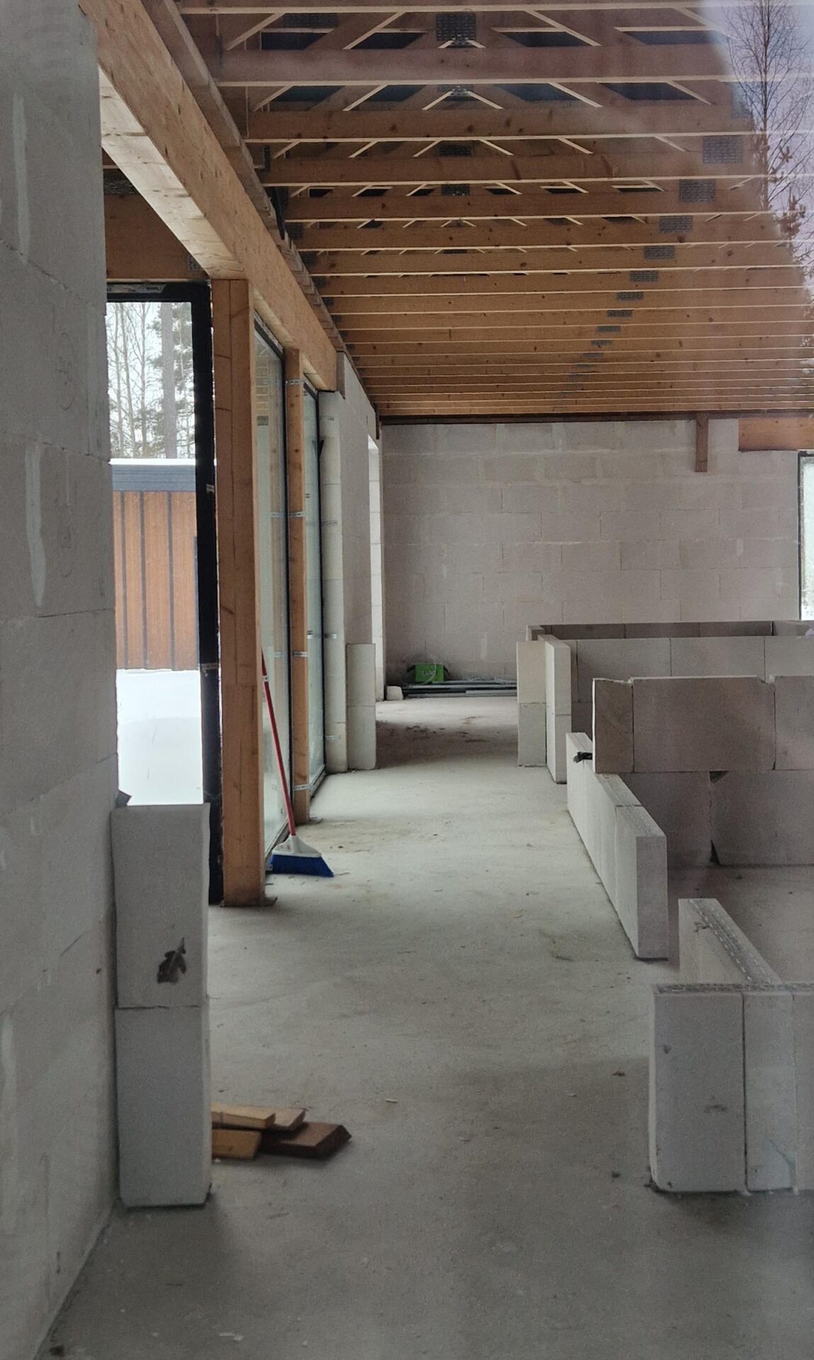 Interior during construction: the central hallway with exposed block walls and timber roof joists.